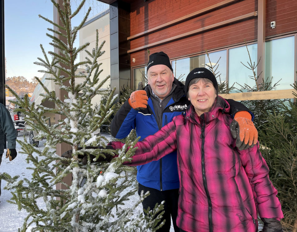 man och kvinna utomhus med en gran