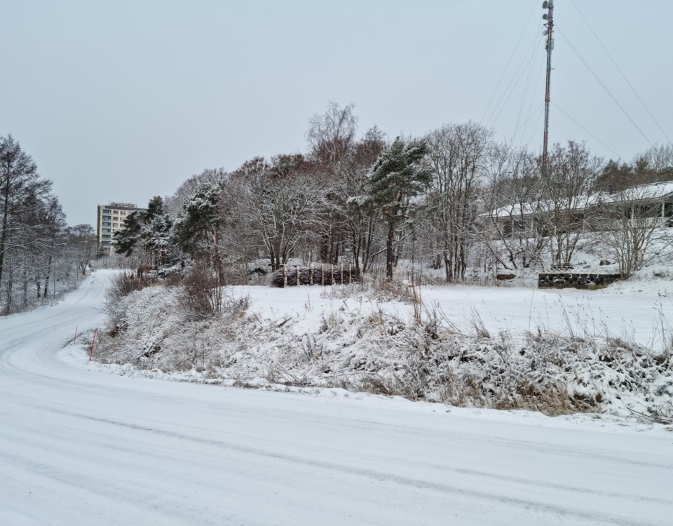 Tom tomt vid sidan av en väg. Vinterlandskap.