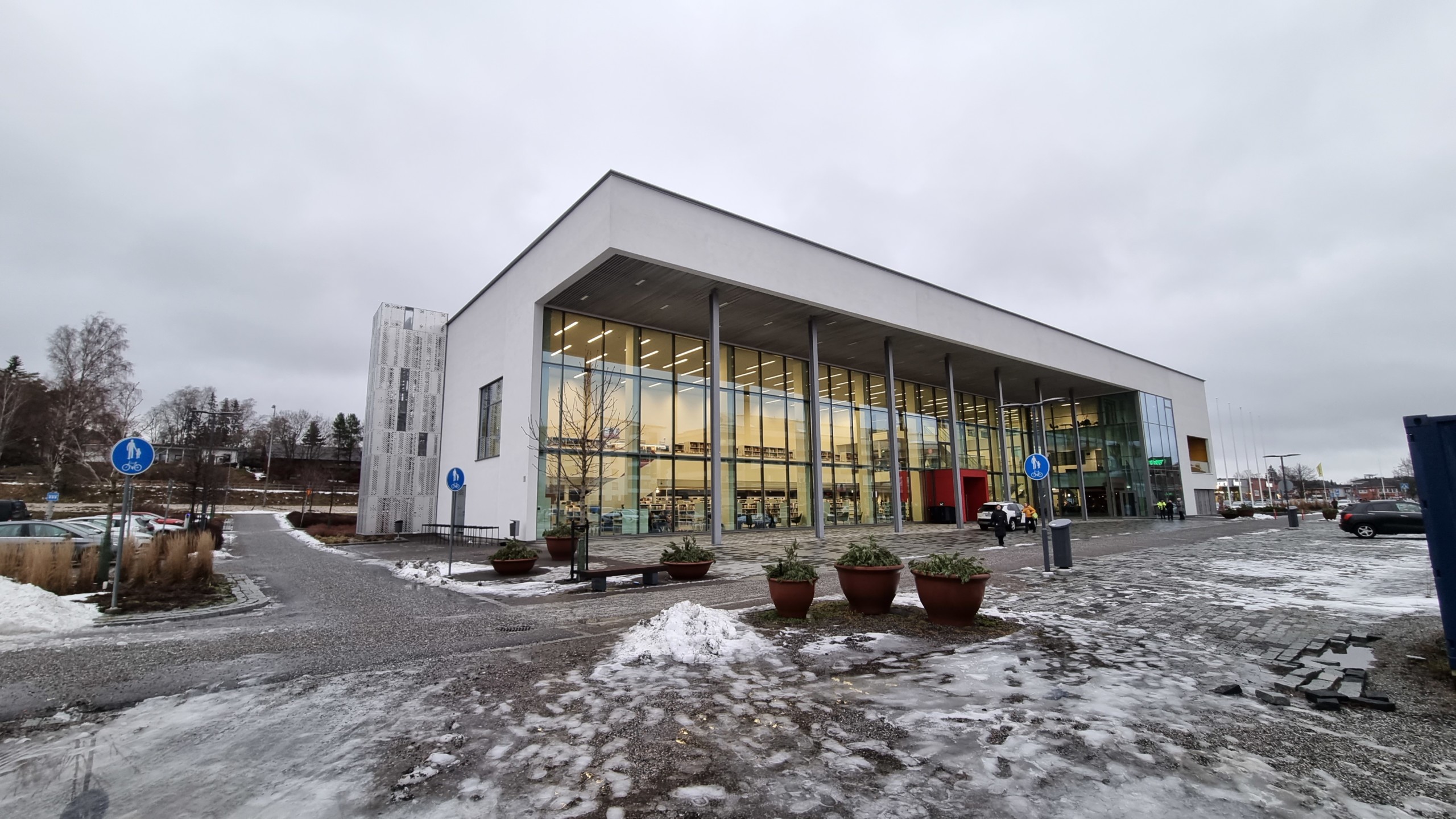 en stenbyggnad med en glasvägg i vinterslasket