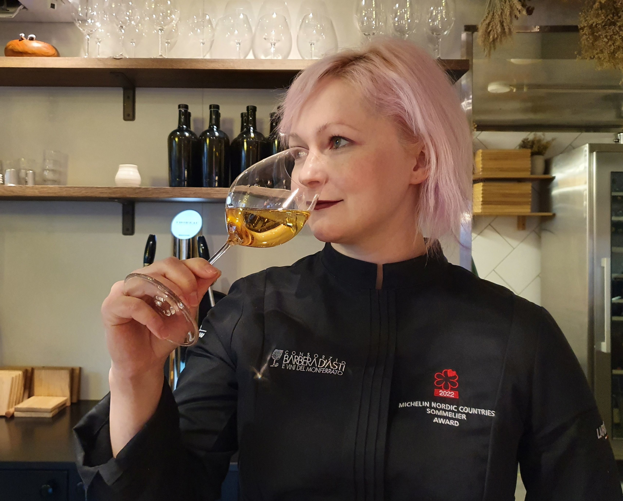 En kvinna som smakar på ett vin.