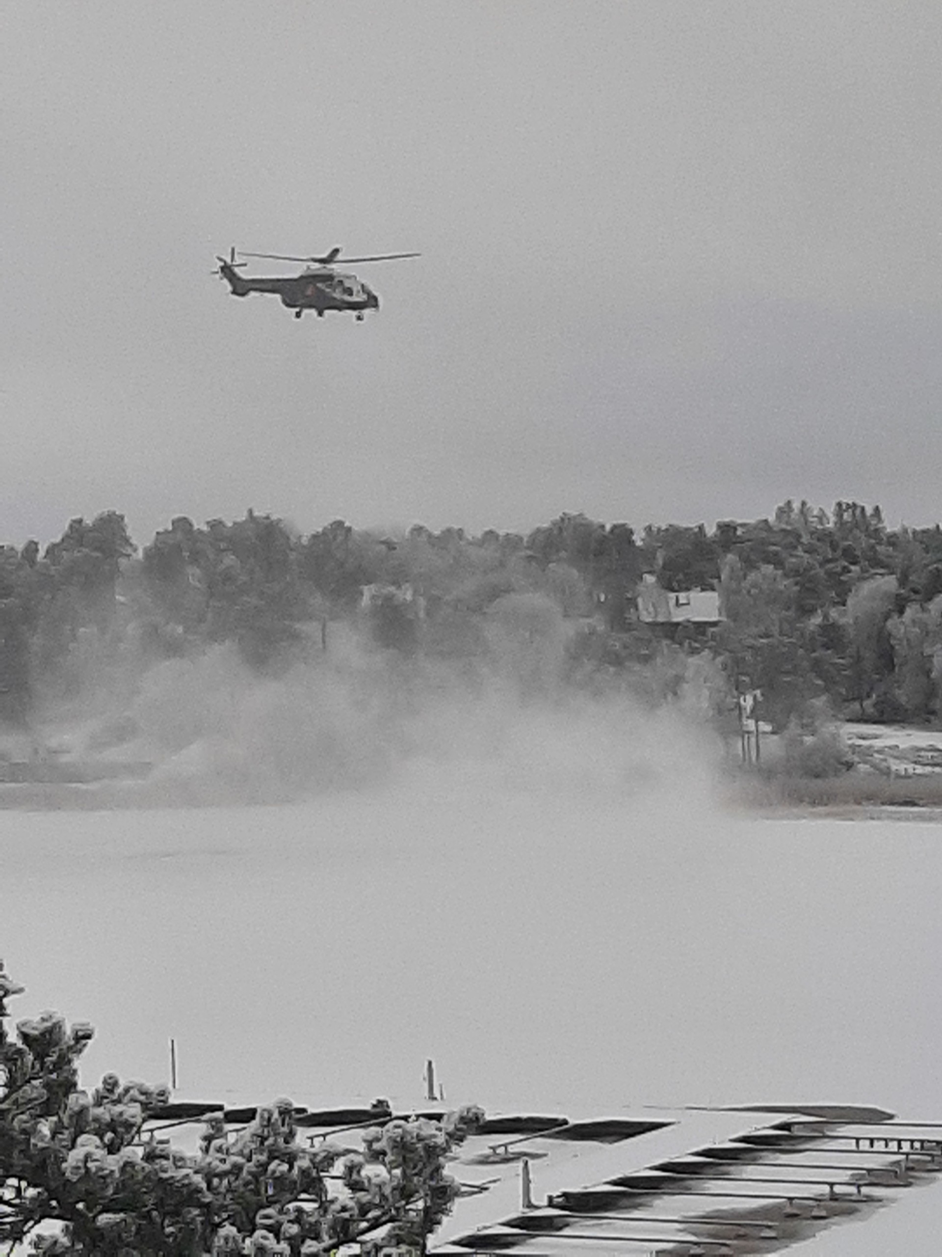 Helikopter flyger över vinterlandskap