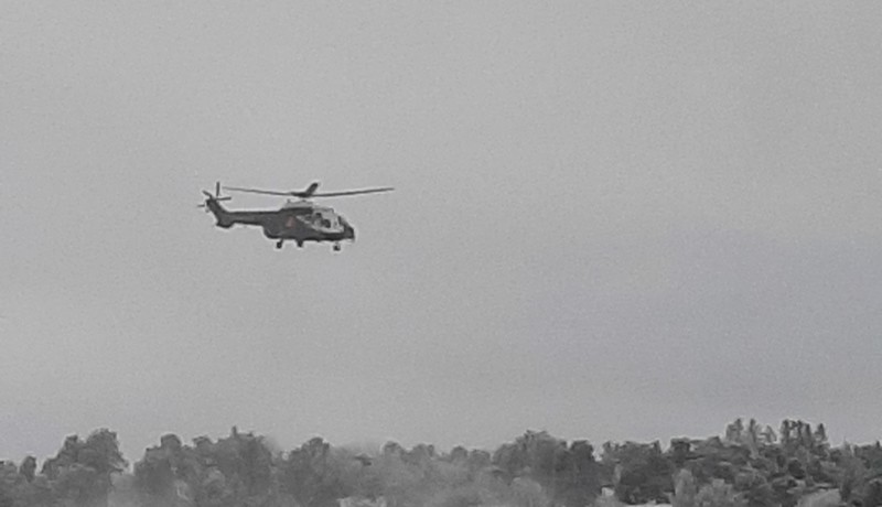 Helikopter flyger över vinterlandskap