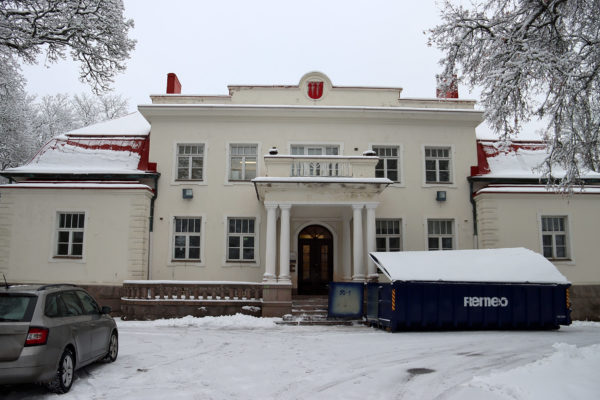 En stor vit byggnad forograferad utifrån.