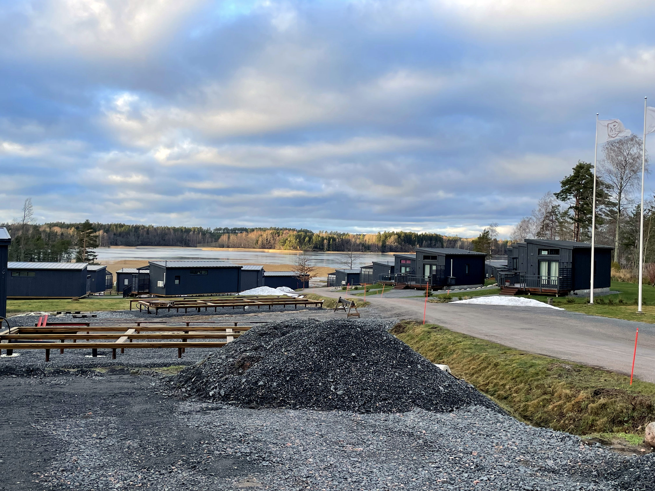 område med ett bygge i förgrunden. små villor och havet i bakgrunden