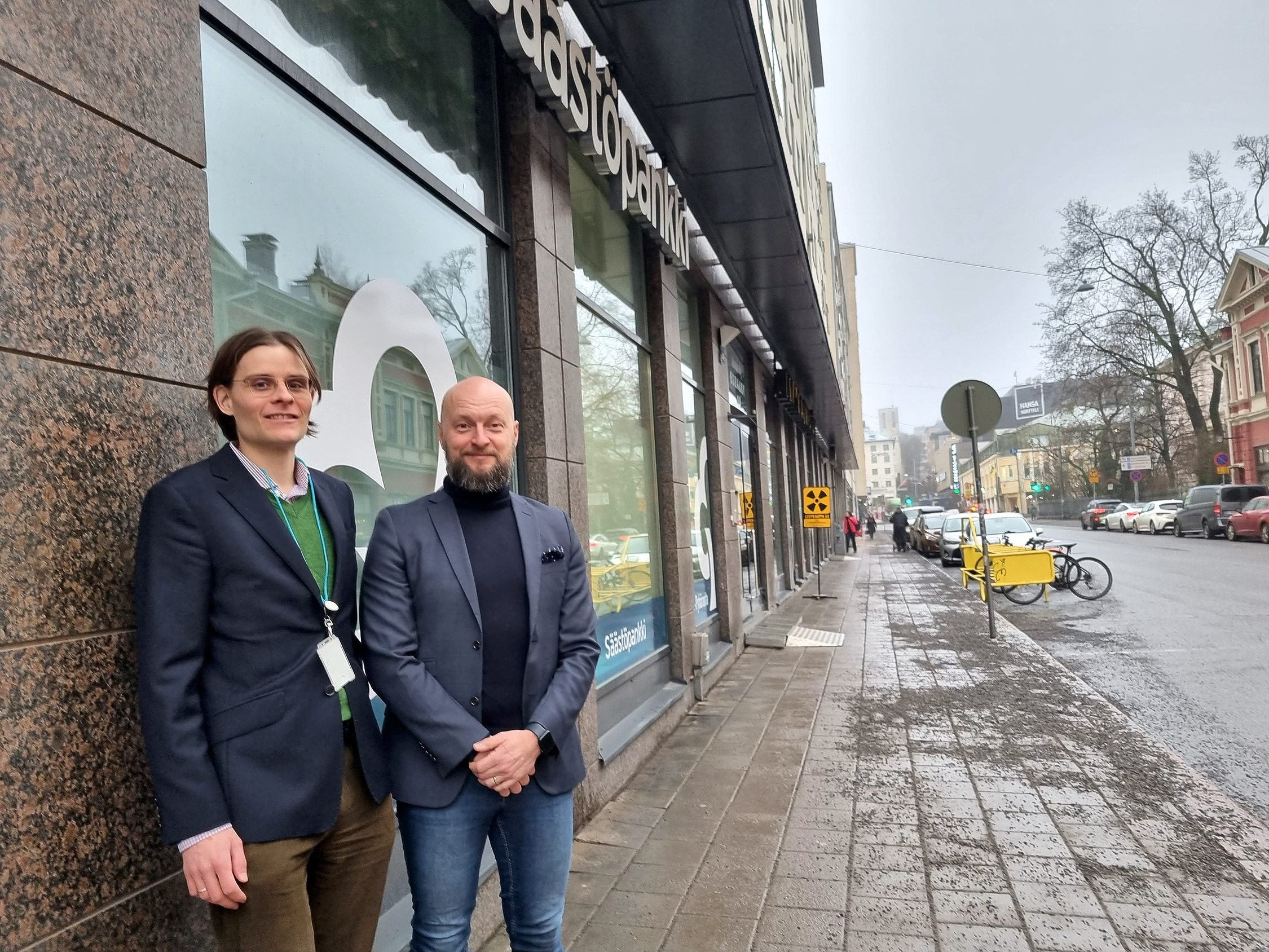 Två män utanför en byggnads skyltfönster.