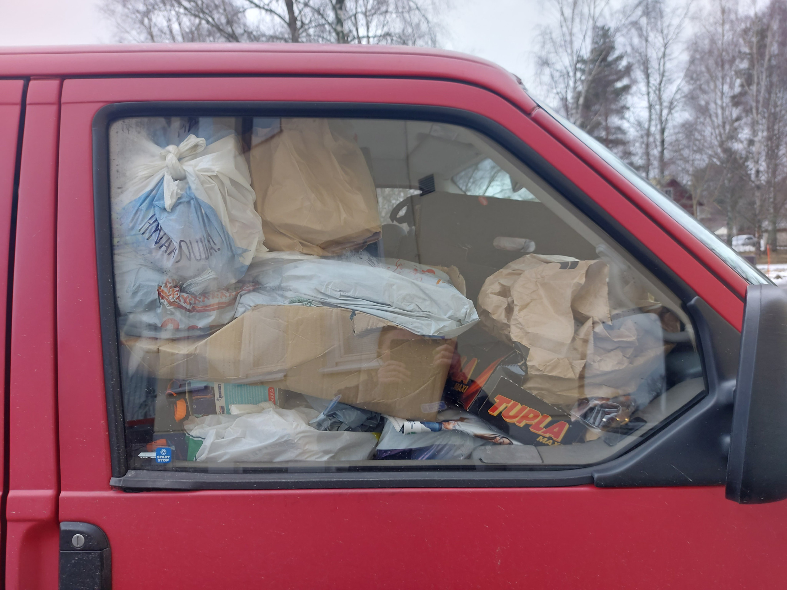 Röd paketbils förarhytt fylld med bråte
