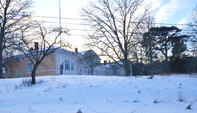 en gul stenbyggnad i vintermiljö