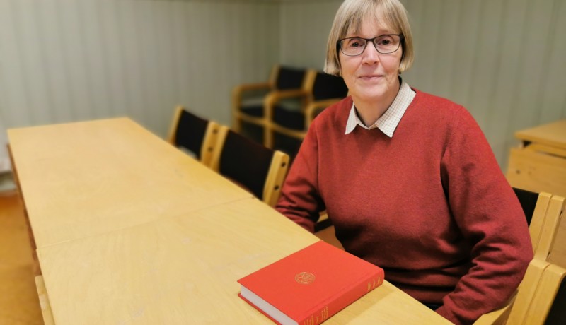 kvinna vid bor med bok