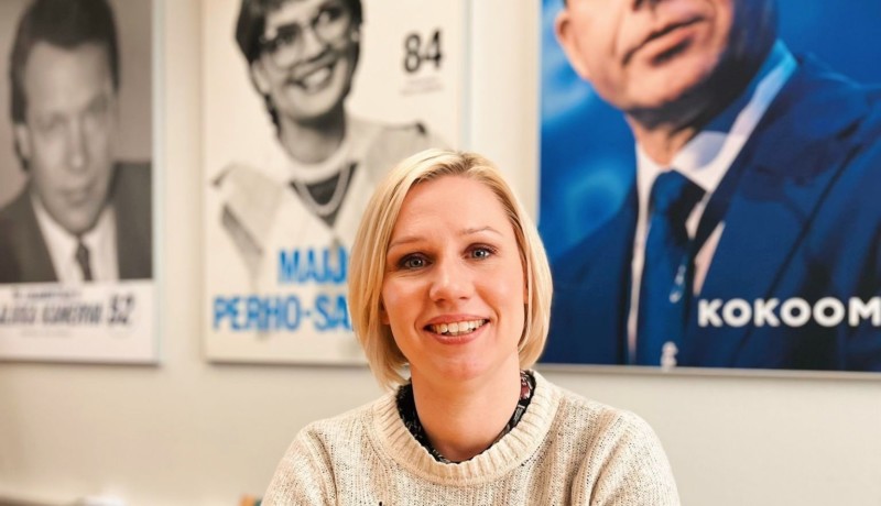 kvinna med ljust hår framför partiledaraffischer