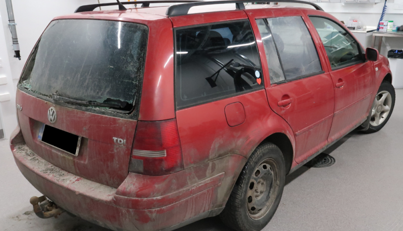 Sliten röd VW Golf i polisens förvar.