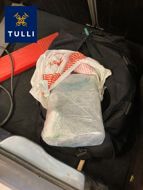 Paket i vitt emallage ligger på en svart bag. Tullens logotyp uppe i vänstra hörnet.