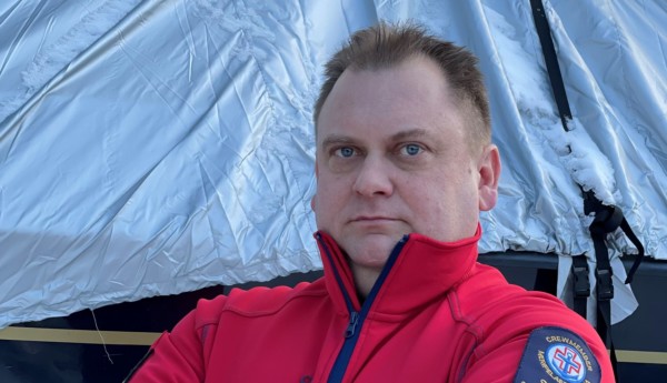 en man står med korslagda armar