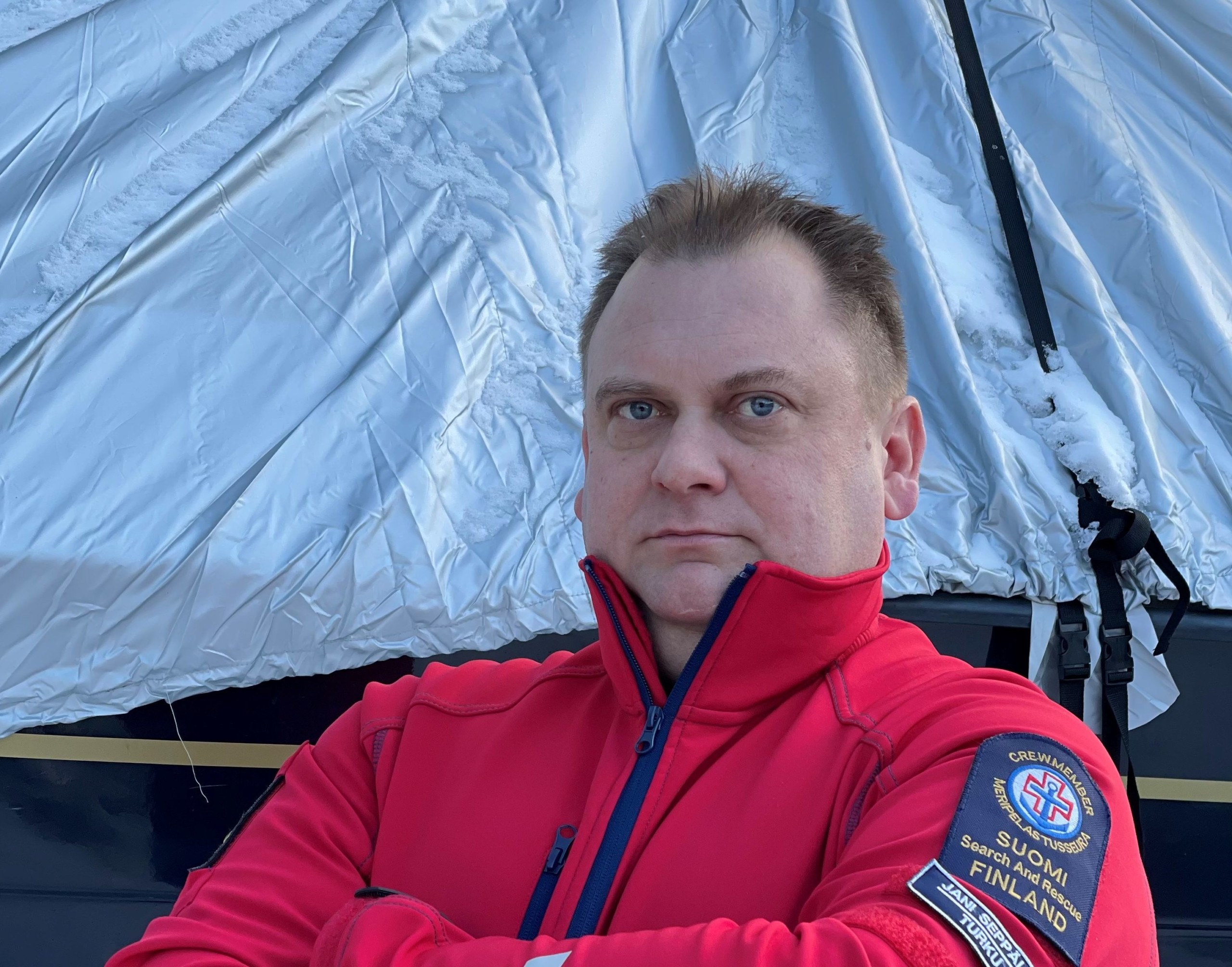 en man står med korslagda armar