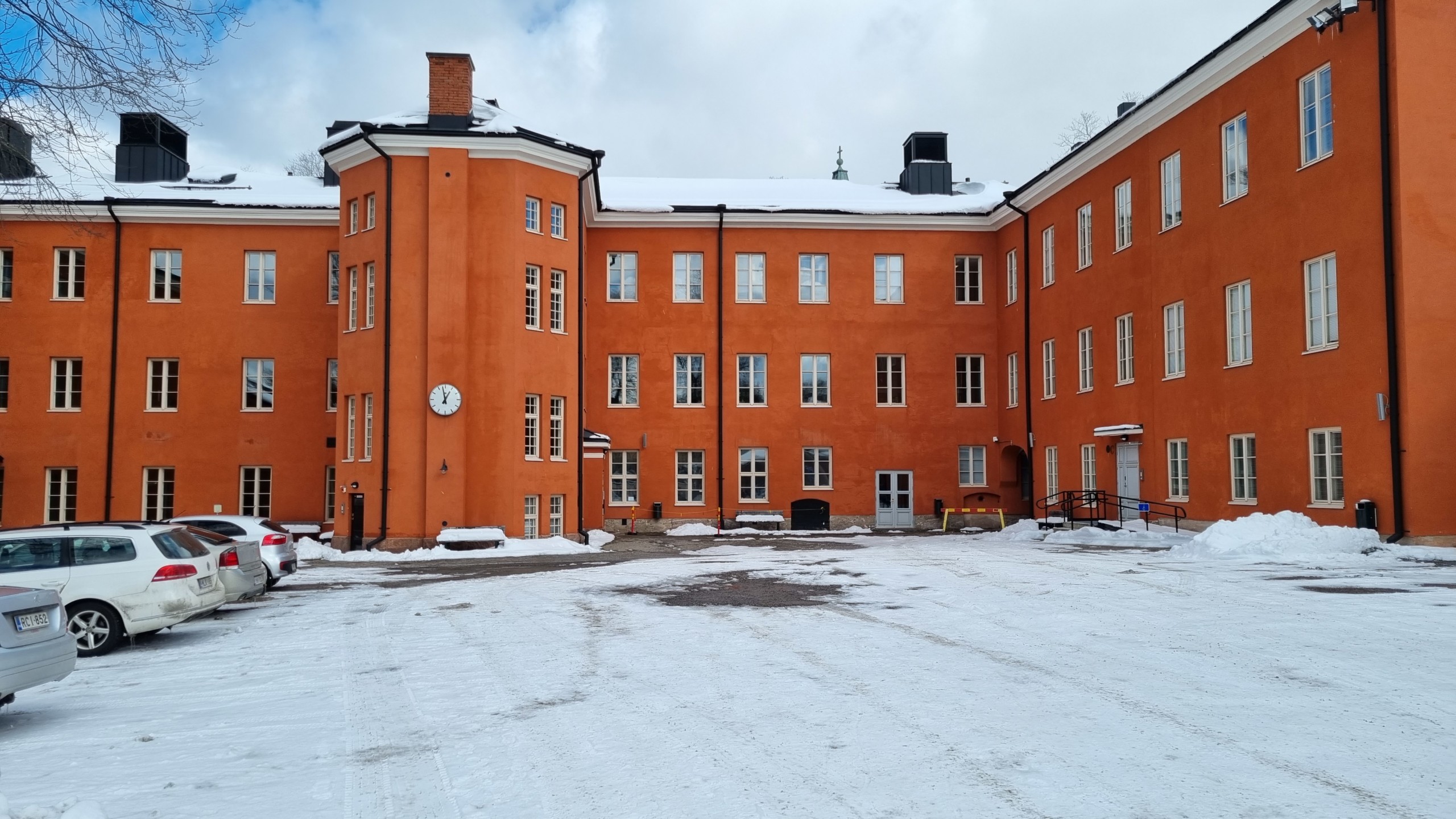 stor röd gammal skolbyggnad med snö framför