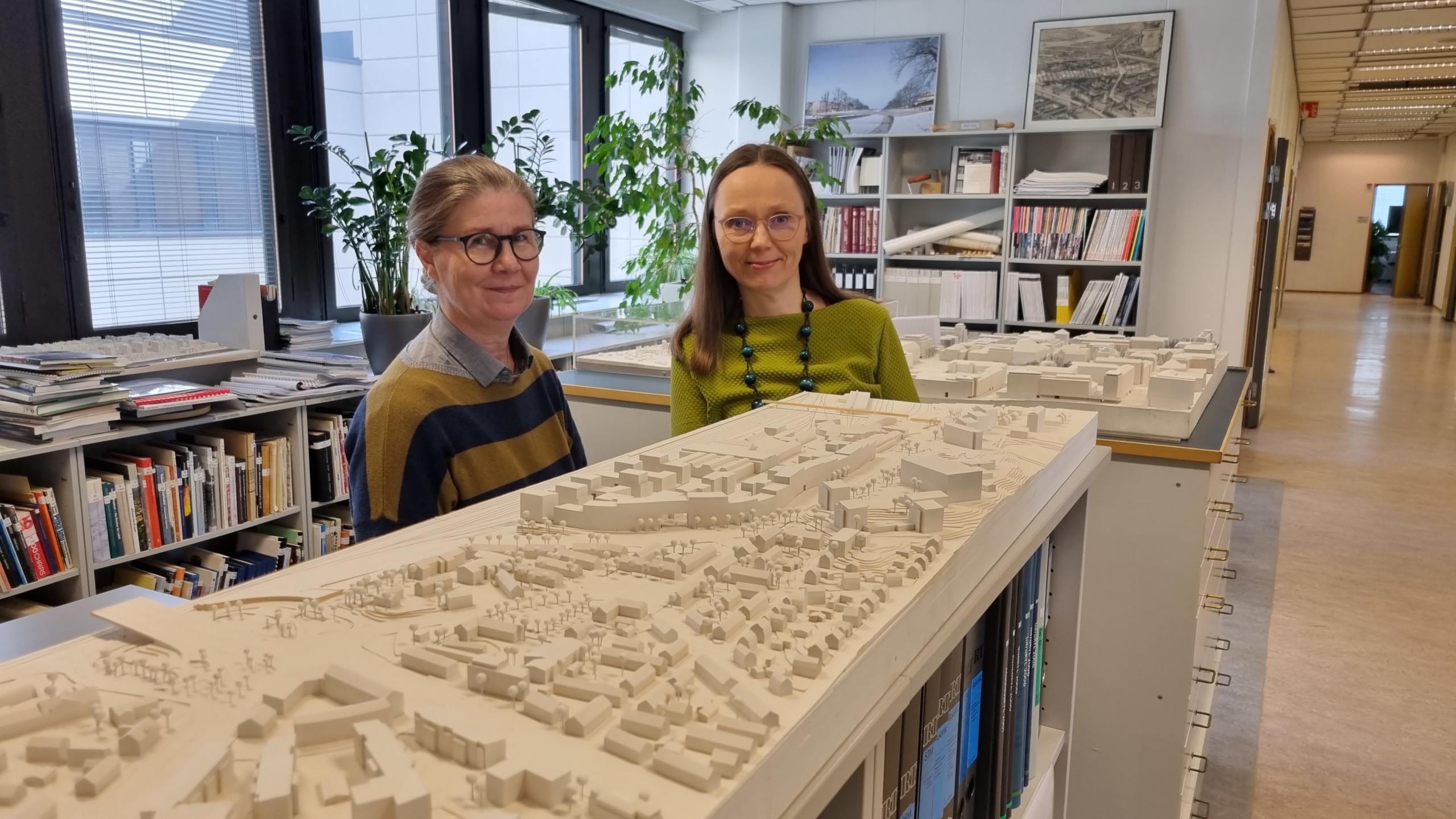 två kvinnor bakom en modell i vitt av hur en stad kunde se ut