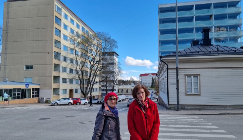 två kvinnor på en stadsgata med höghus bakom