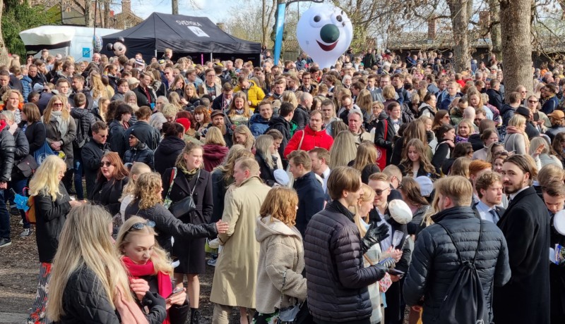 massor med vårklädda människor i en park