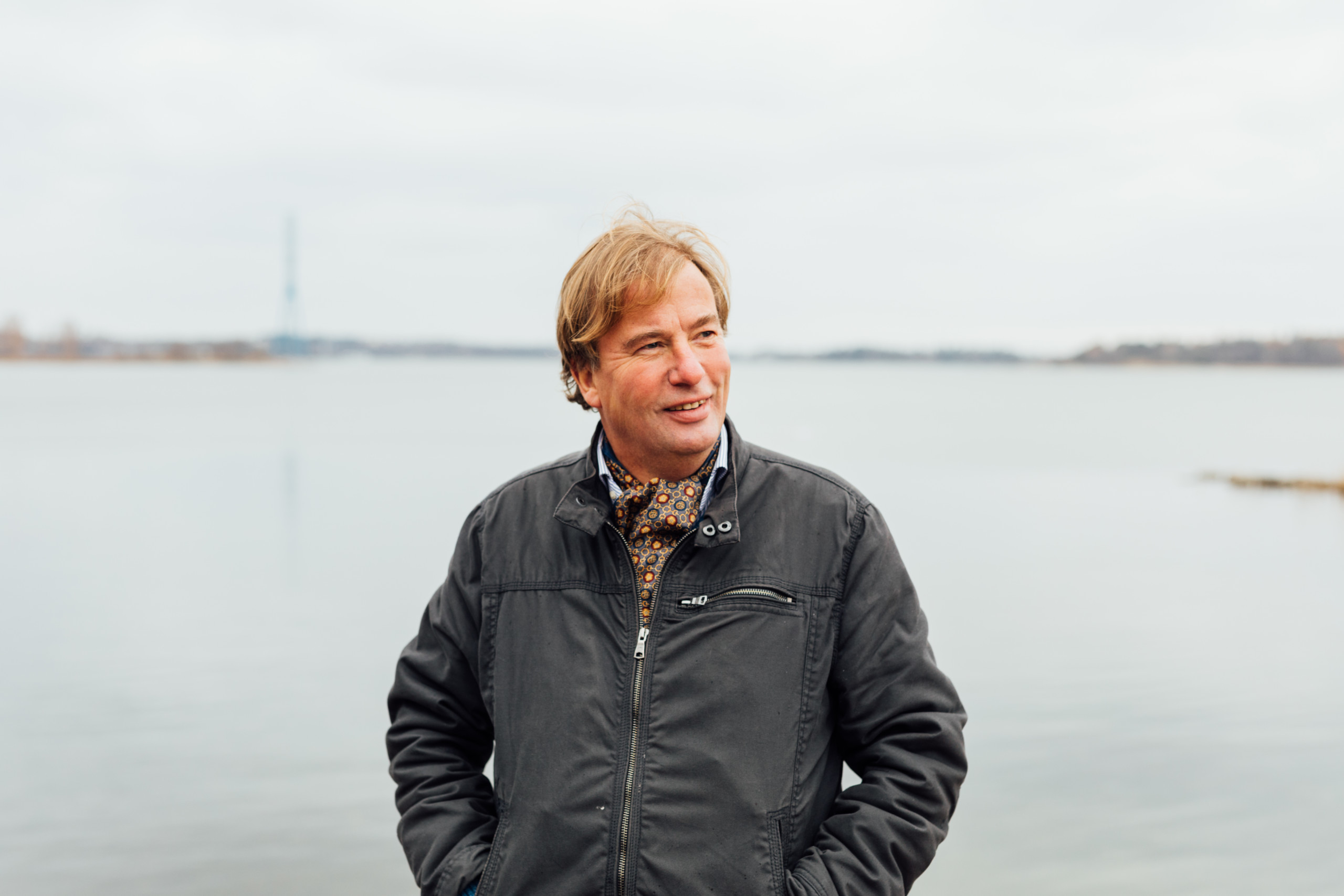en leende man står vid vattnet