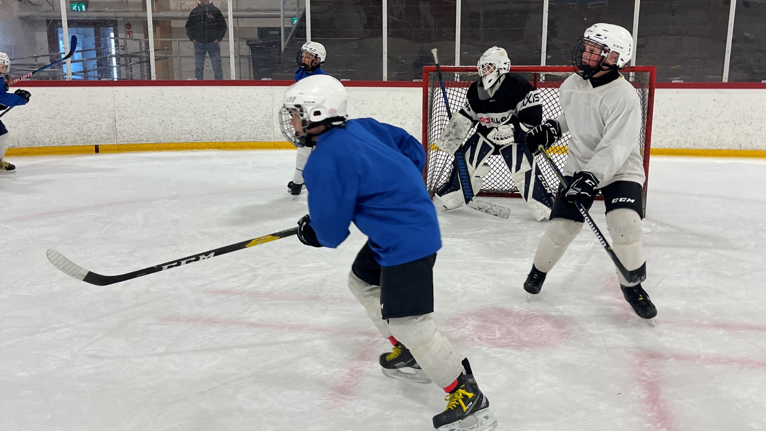 Juniorhockeyspelare tränar i ishall.