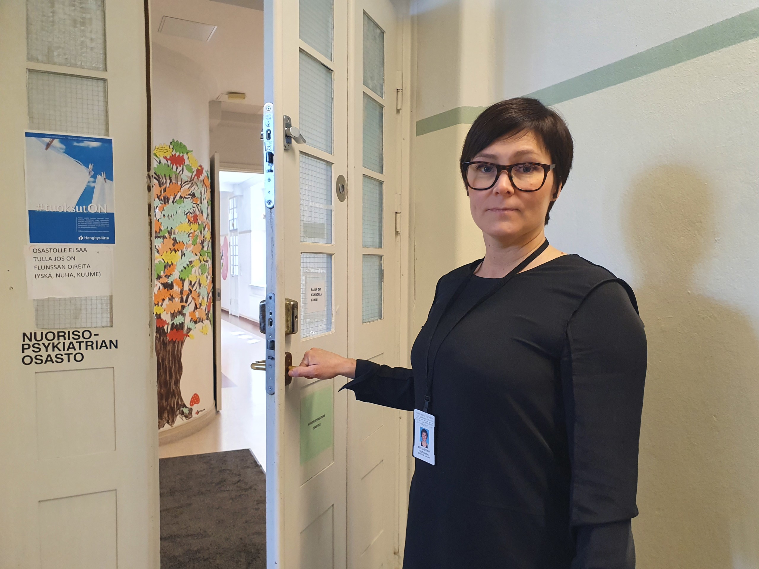 En kvinna som håller upp en dörr.