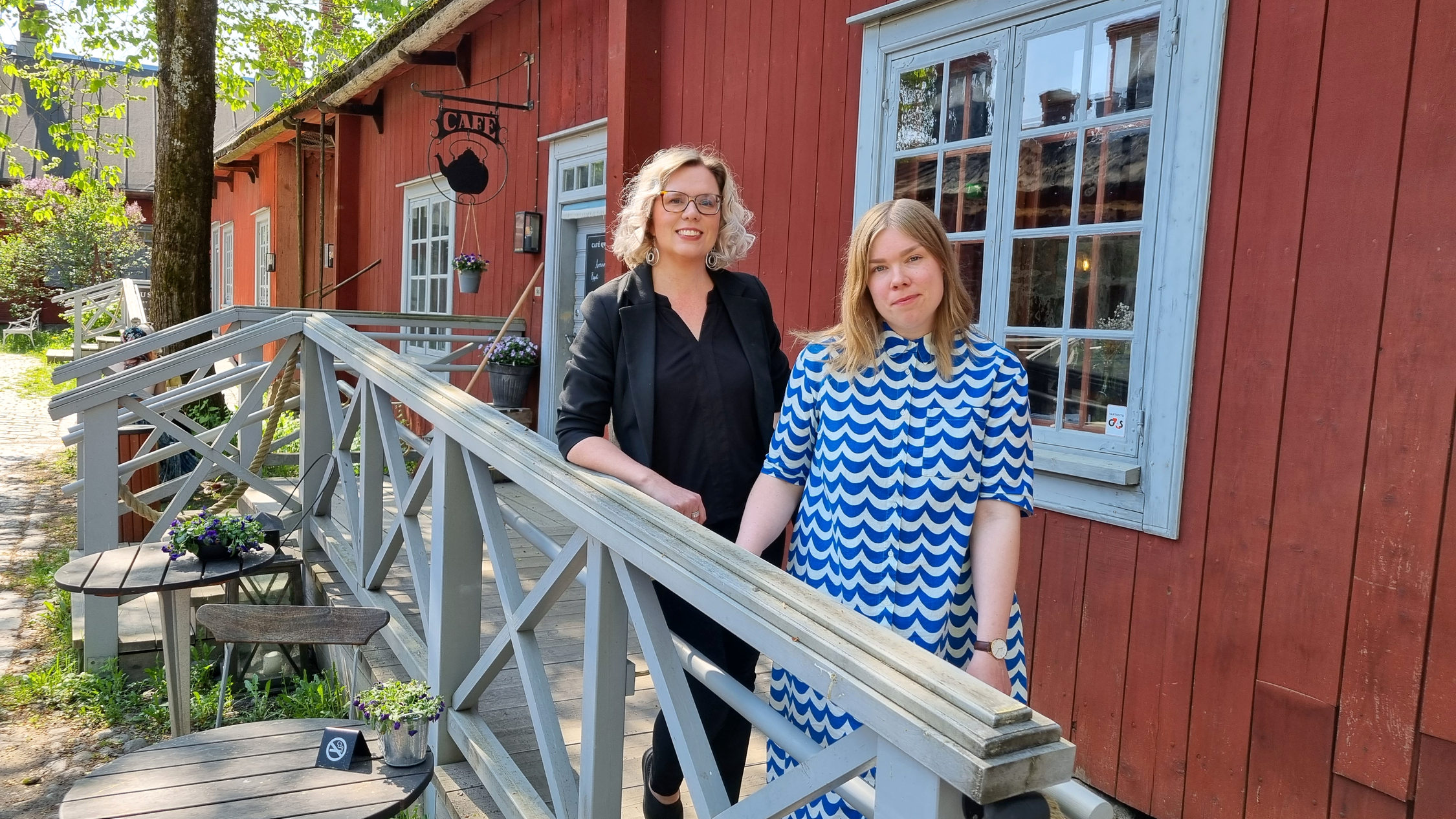 Två kvinnor framför en gammal cafébyggnad
