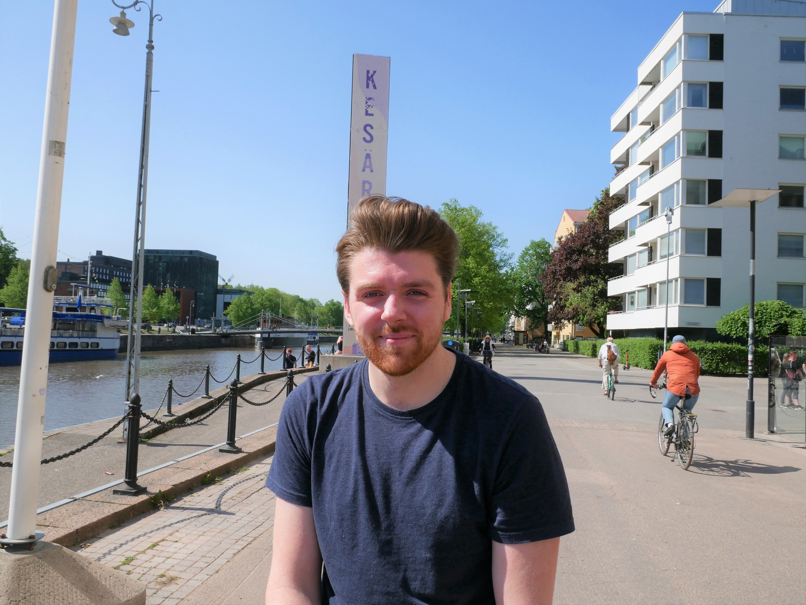 Ung man i solig stadsmiljö
