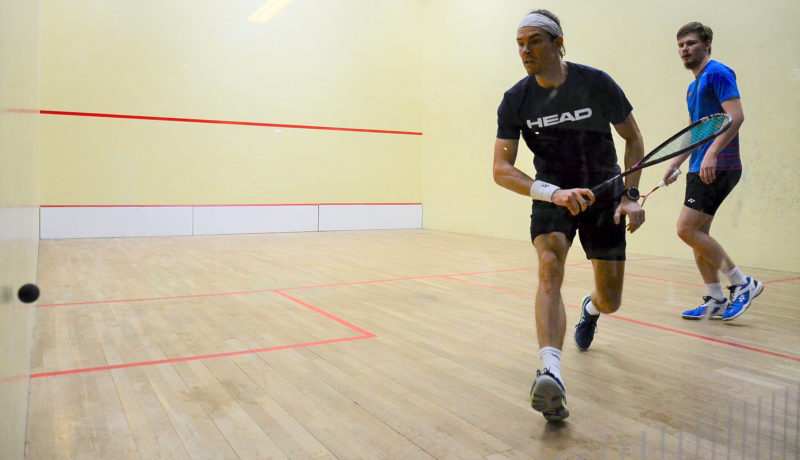 Två män spelar squash.