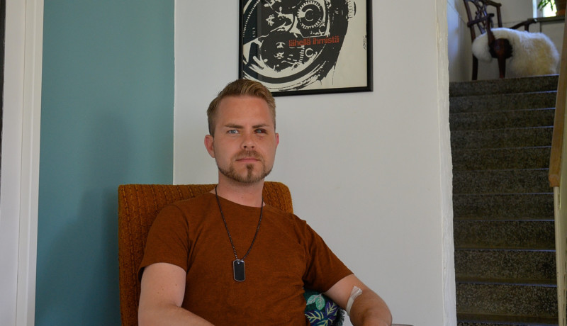 En man sitter på en stol, han har ett rött öga som följd av attacken.