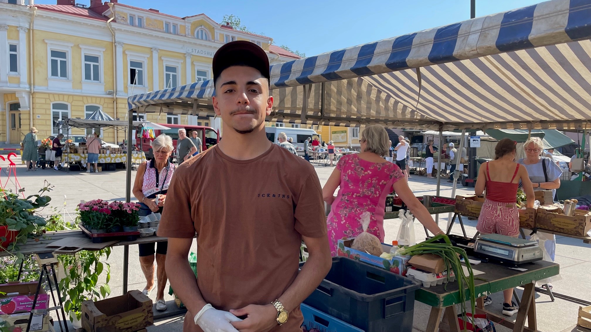 Pojke jobbar som försäljare på torg.