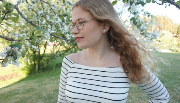 Ung kvinna i en trädgård