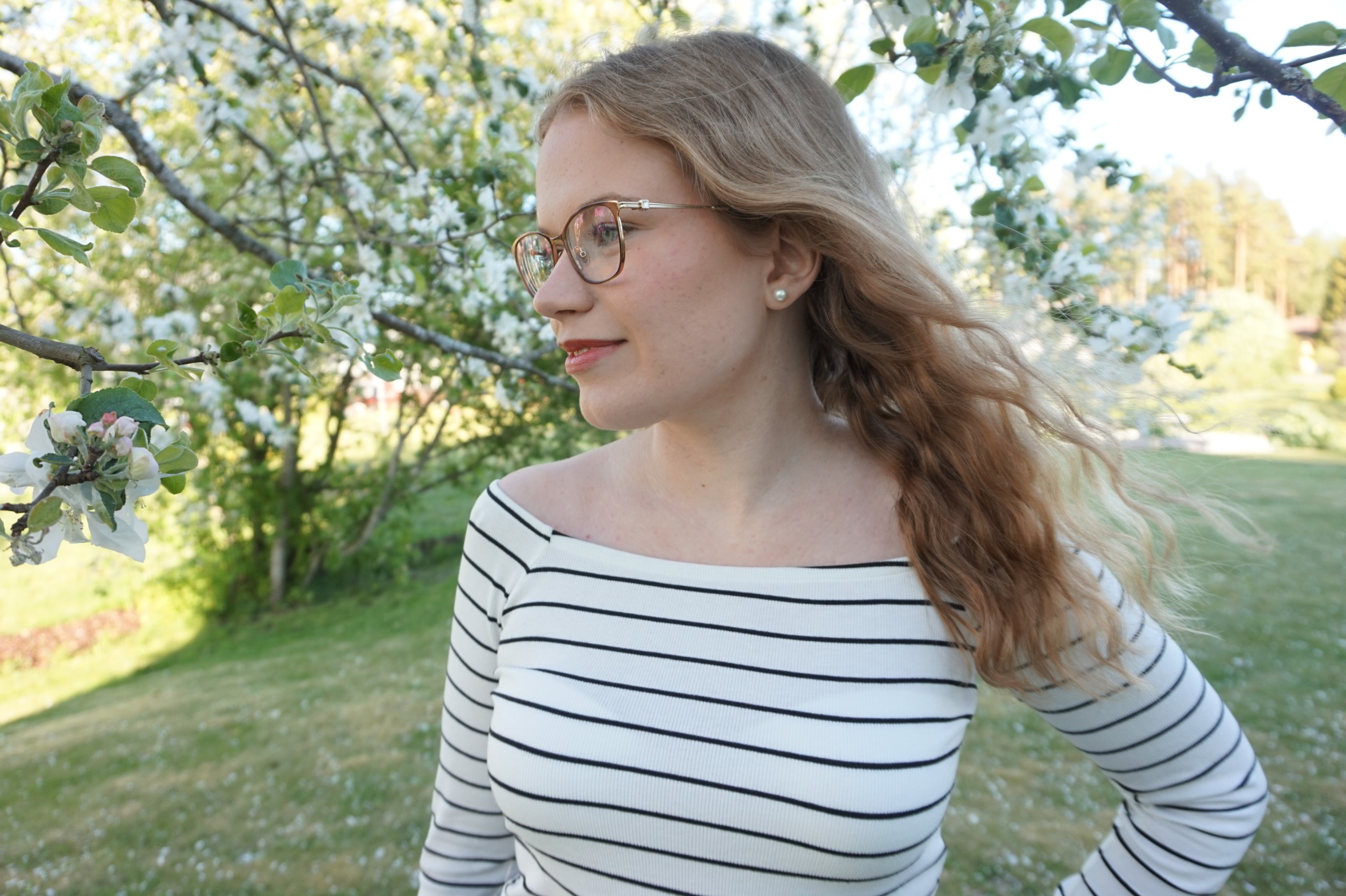 Ung kvinna i en trädgård
