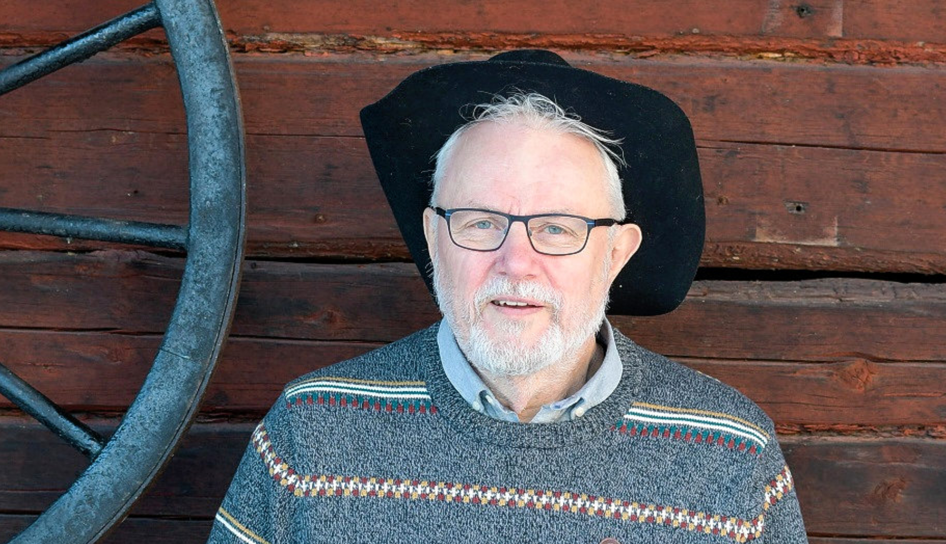 Vithårig man med glasögon och en svart filthatt på huvudet