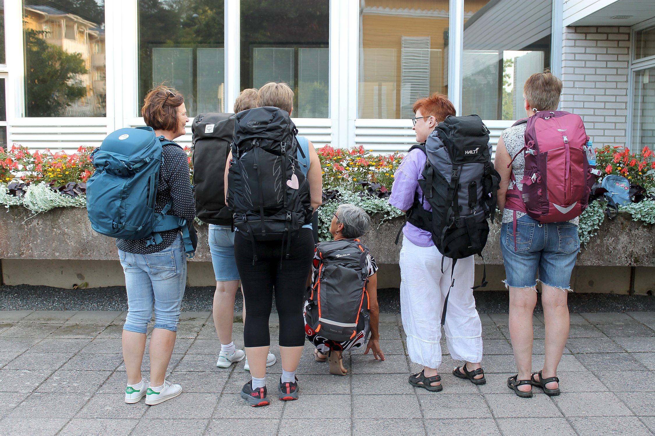 Grupp människor med ryggsäckar på ryggen, gruppen ska på en pilgrimsvandring i Spanien.