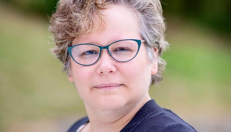 kvinna med glasögon tittar mot kameran
