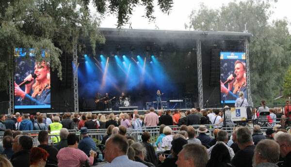 Sanna Nielsen står på scenen i Stallörs parken i Ekenäs. Framför scenen är många människor.