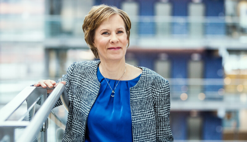 kvinna i blått mot blågrå bakgrund