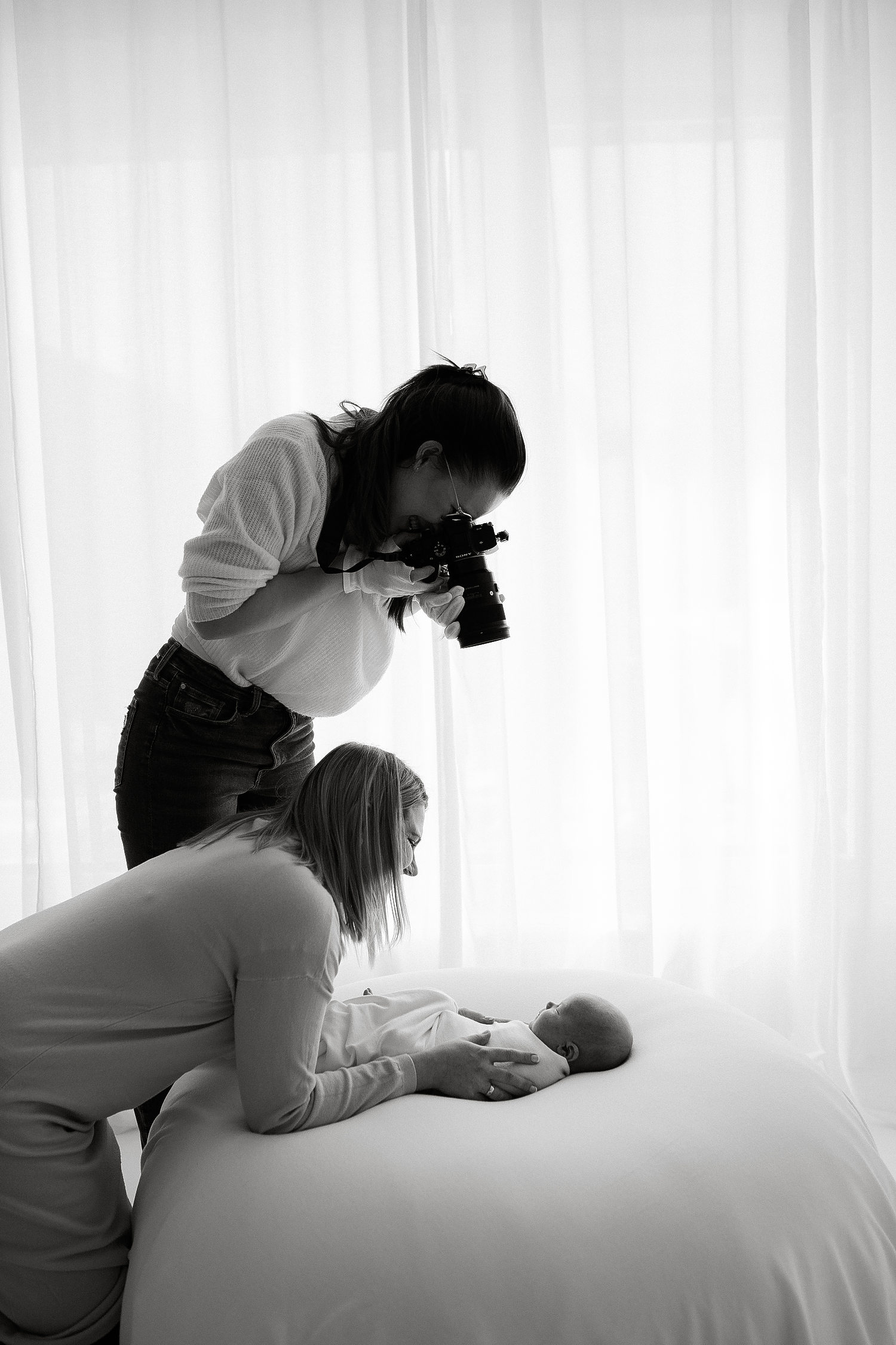 fotograf fotograferar ett barn tillsammans med mamman