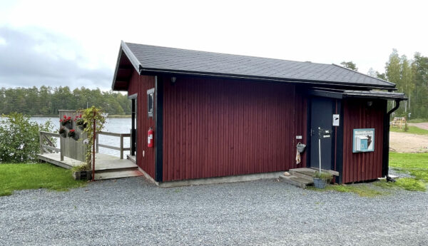 Röd byggnad vid vatten.