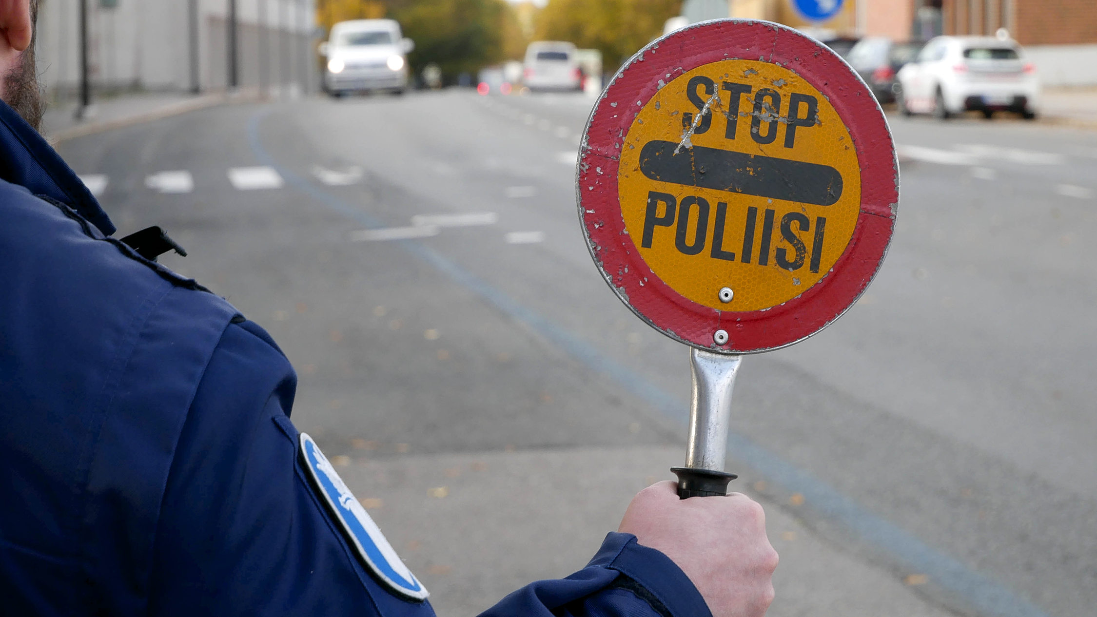 en polis håller i en stoppskylt