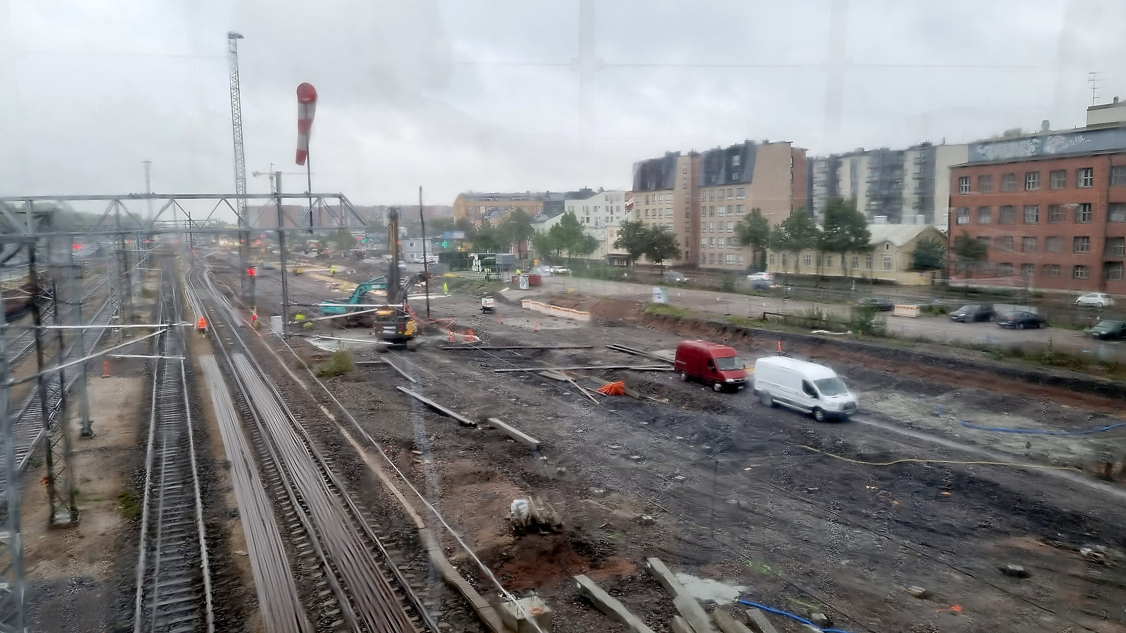 byggarbetsplats vid bangård, fotad uppifrån genom regnigt fönster