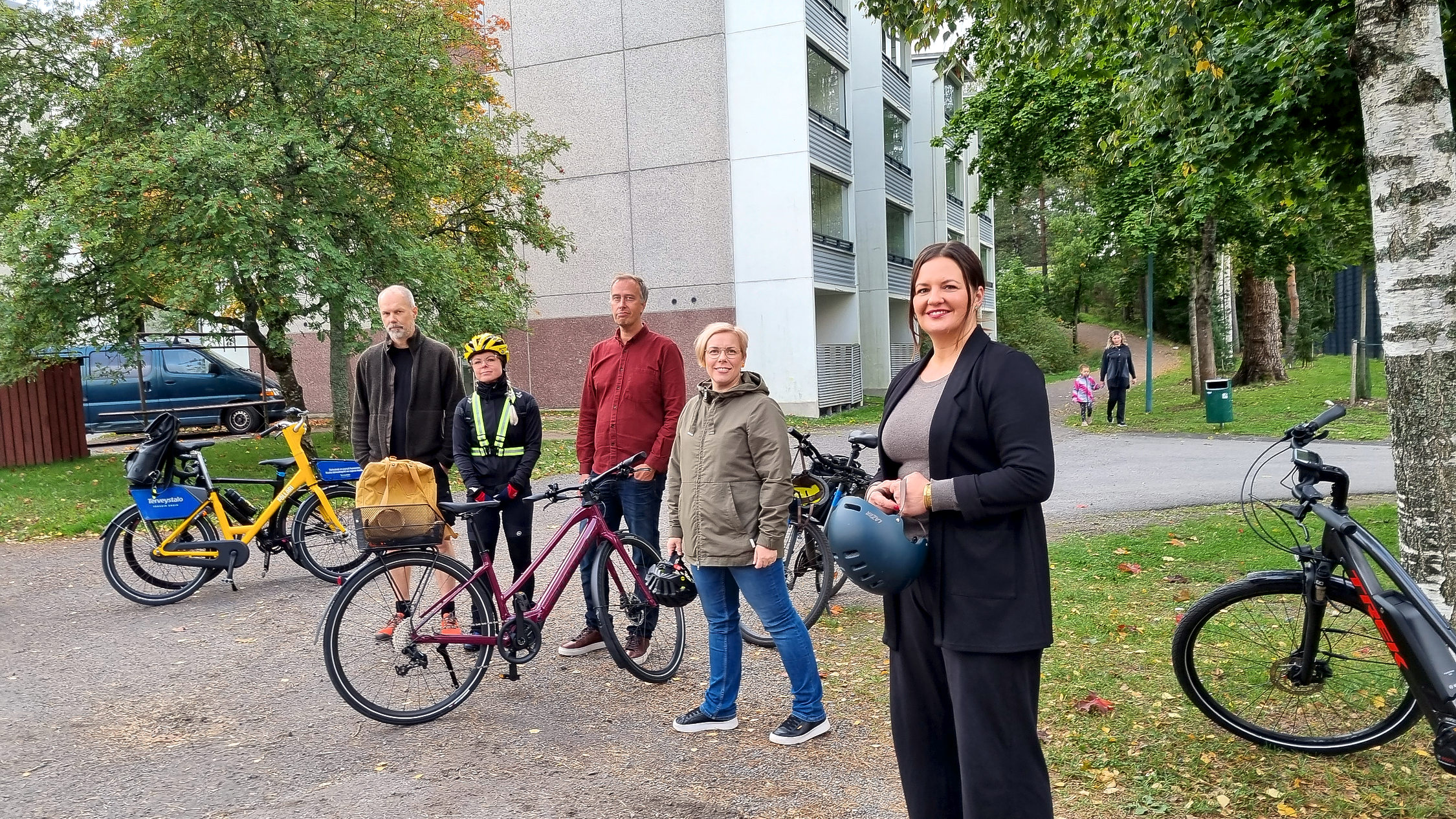 Flera personer med cyklar med höghus bakom
