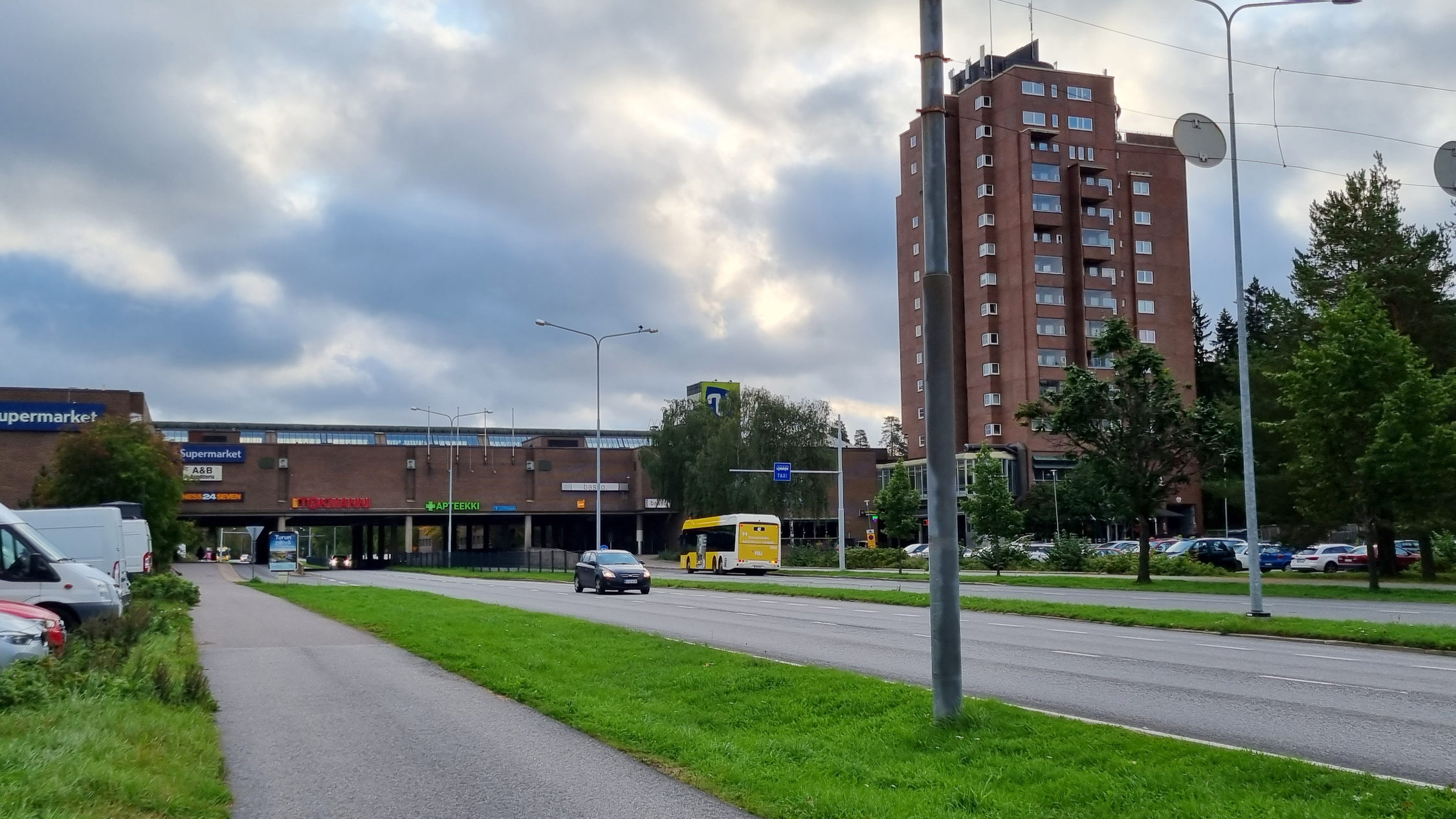 Högt hus i förort till höger, gata i främre delen av fotot