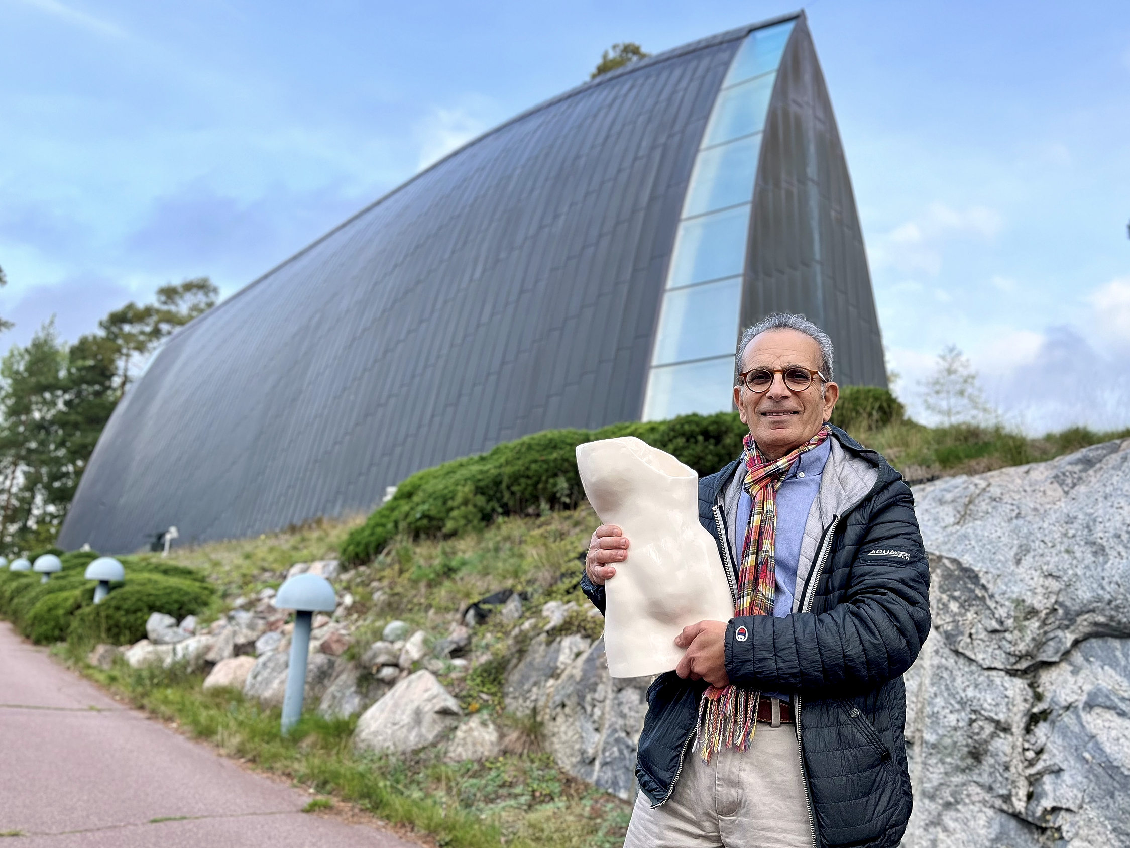 man håller upp skulptur