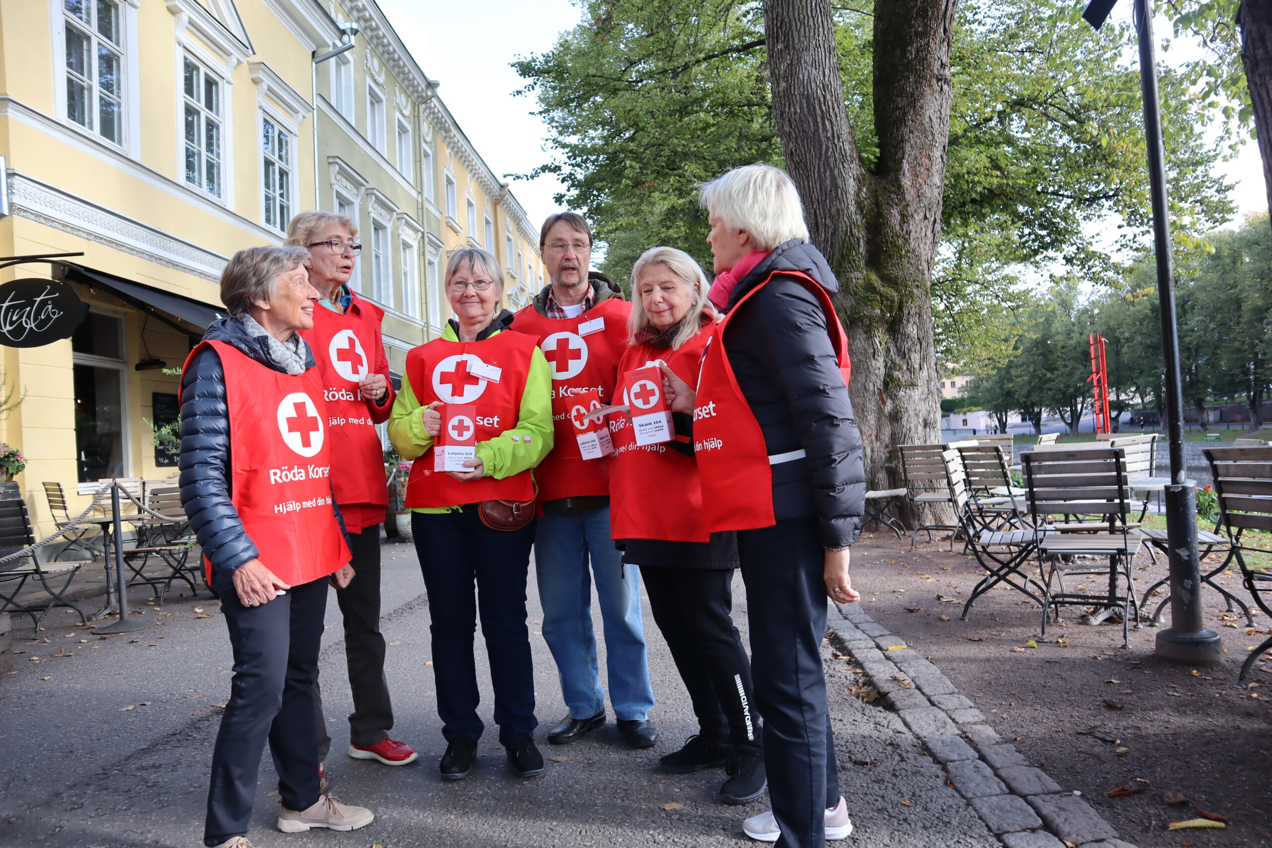 Ett gäng rödvästklädda personer på en gata