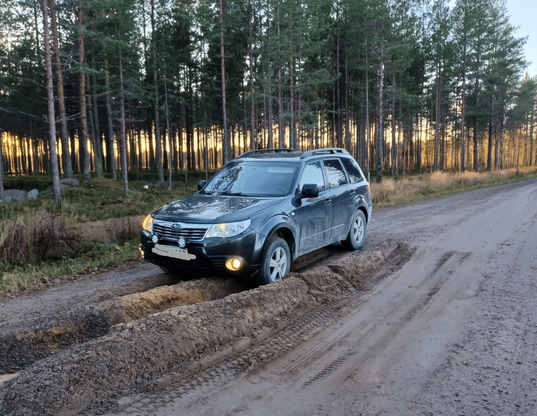 En bil som kört fast på en väg med djupa fåror.