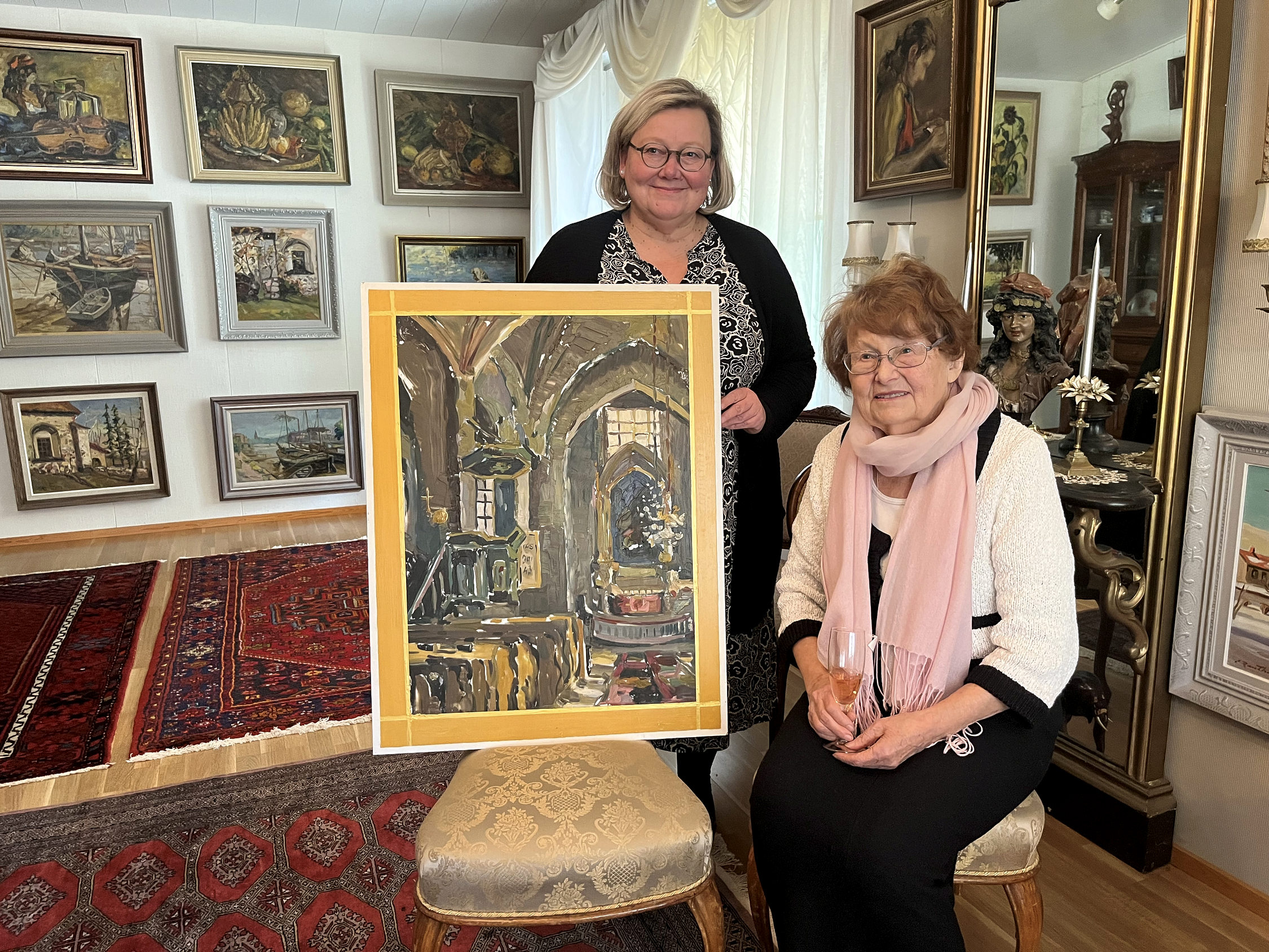 två kvinnor vid en tavla