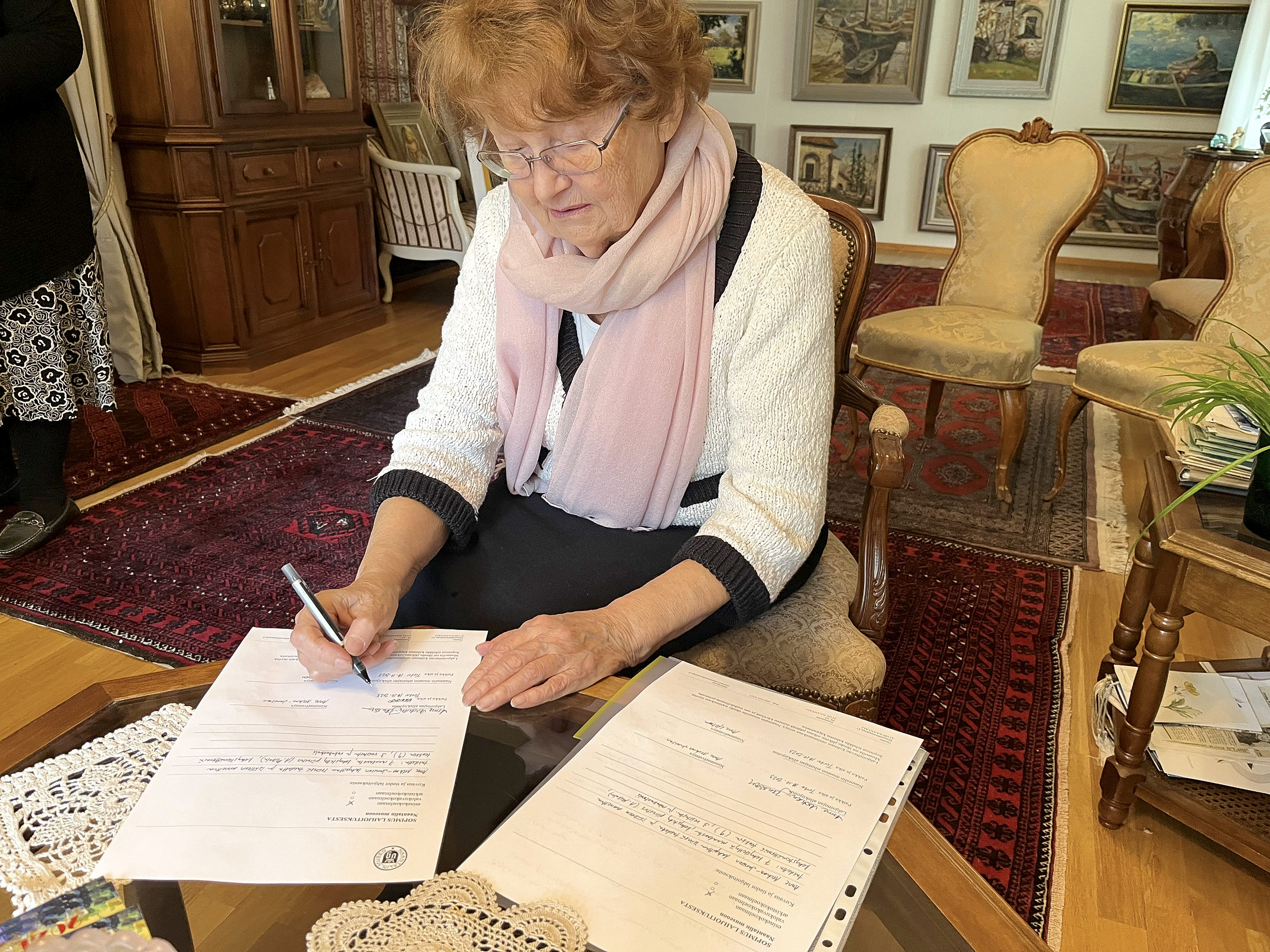 kvinna undertecknar konstdonation
