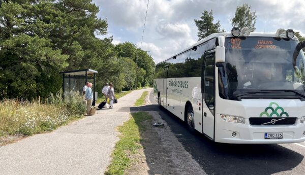 en vitgrön buss vid en busshållplats