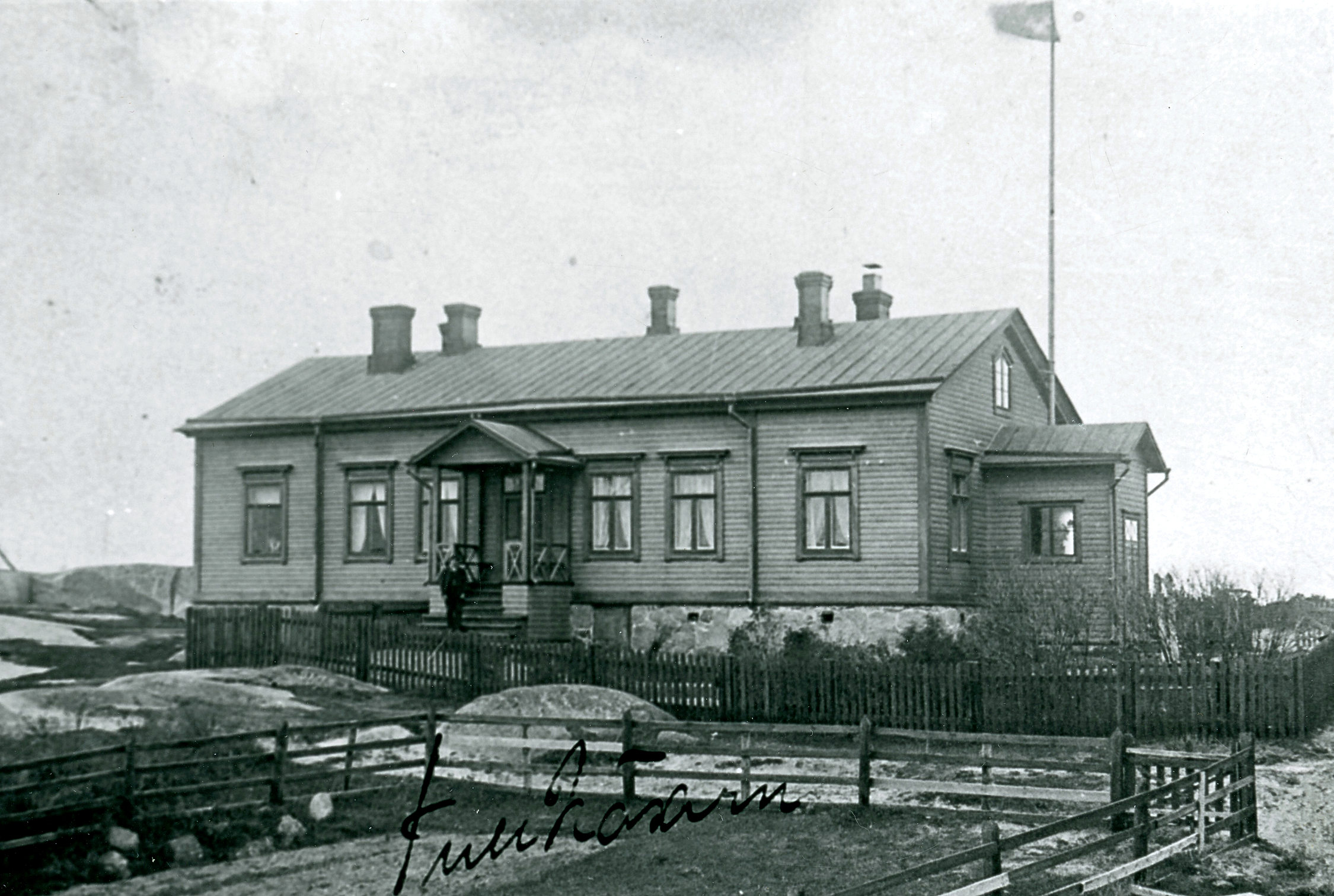 Svartvitt fotografi av tullstation i trä.