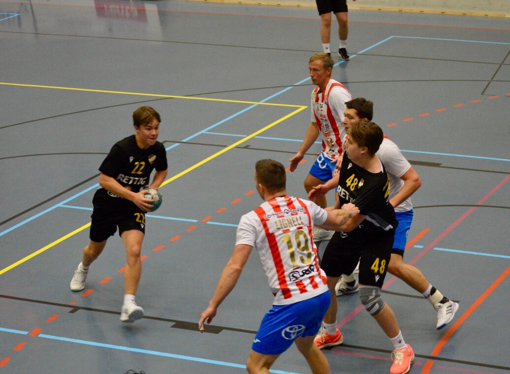 En kvintett handbollsspelare i kamp om bollen.